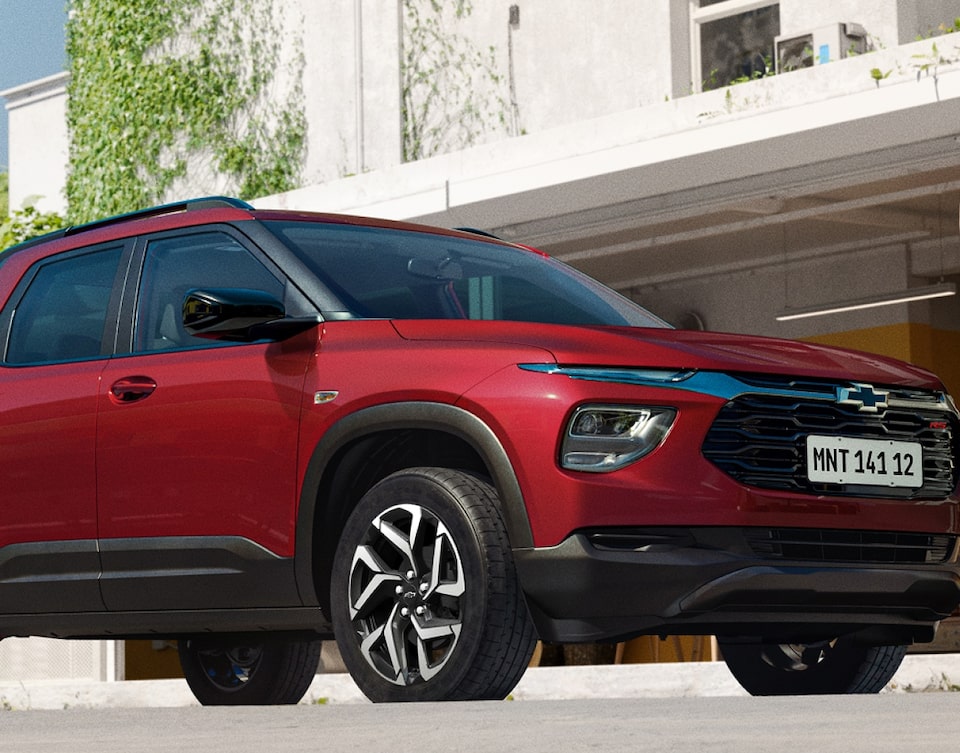 Tracker SUV Chevrolet rojo estacionado frente a un edificio con lista de gestiones online como licitación, pago y consulta de estado de cuenta en suscripción digital