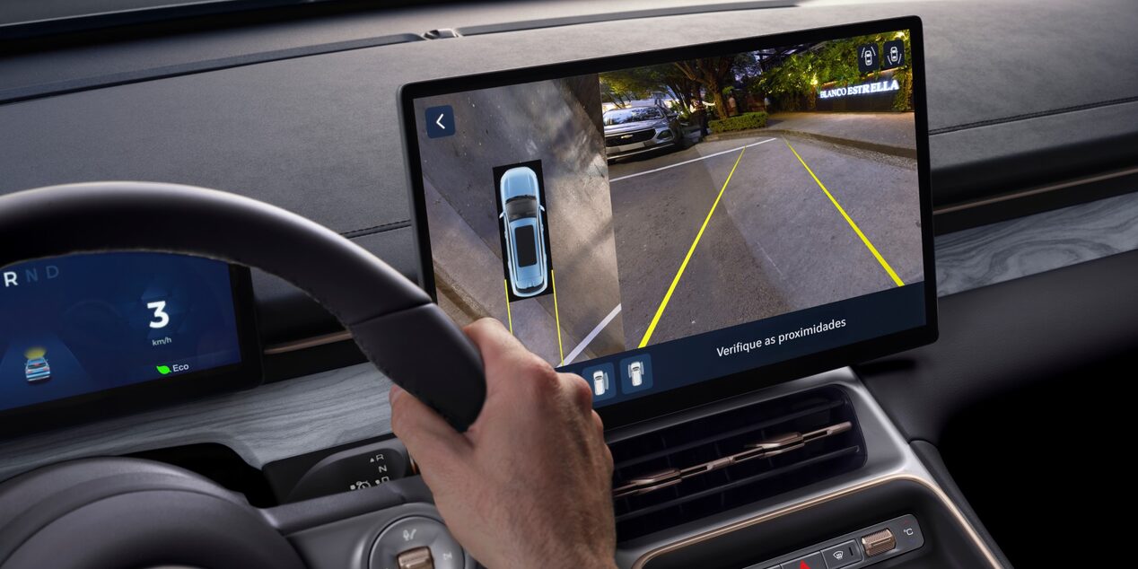 Interior de Chevrolet Captiva Híbrida con sistema de cámaras de visión 360° mostrado en la pantalla central, incluyendo líneas guía de estacionamiento y vista aérea del vehículo para facilitar las maniobras.