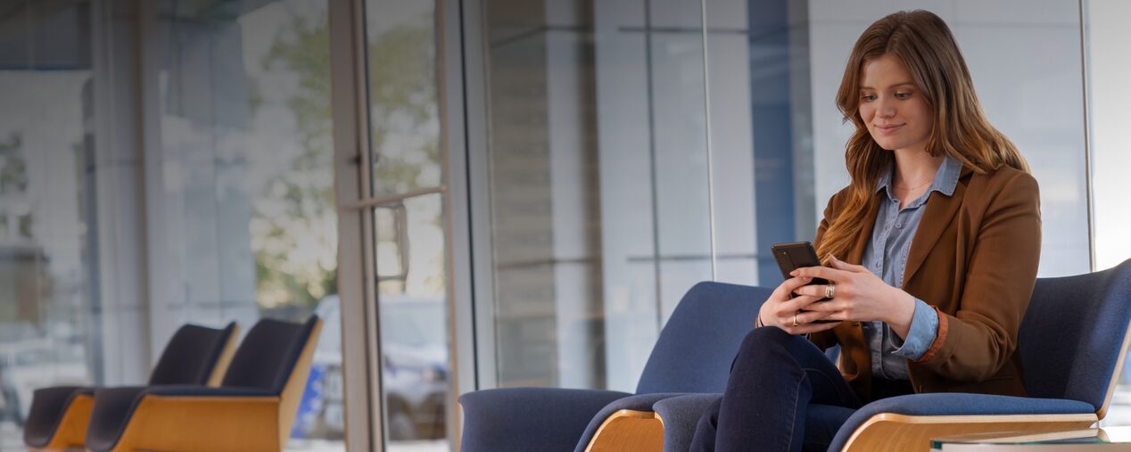 Persona sentada en un entorno moderno mirando un smartphone, junto al título 'Política de Privacidad', imagen que representa el compromiso de Plan Chevrolet con la seguridad y protección de los datos personales de los usuarios según la Ley 25.326.