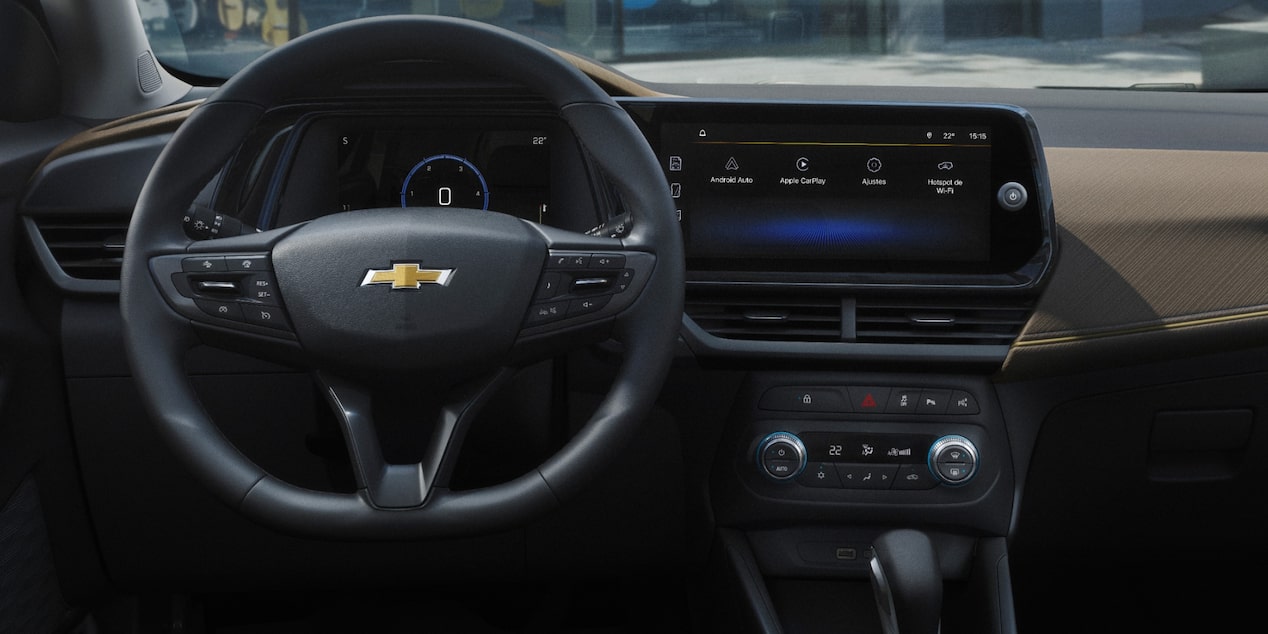  Interior de Chevrolet Tracker con enchufes USB tipos A y C, pantalla multimedia y proyección inalámbrica, mostrando funciones de conectividad y tecnología a bordo.