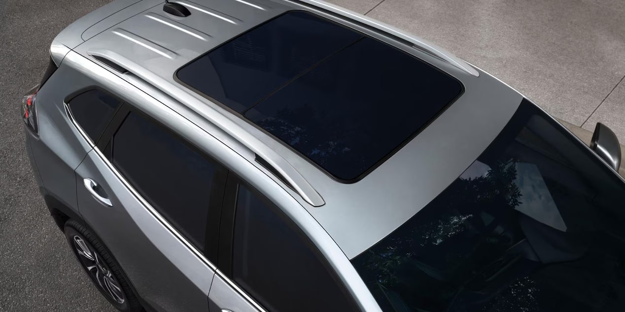 Vista superior de Chevrolet Tracker con rack de techo color negro, alerón trasero y techo solar, destacando el diseño exterior del vehículo.