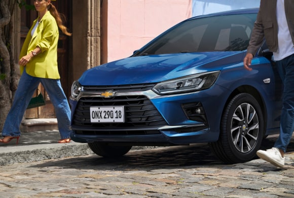 Collage de imágenes mostrando todos los ángulos exteriores del nuevo auto Chevrolet Onix Hatchback 2027 en colores azul y rojo, destacando sus detalles frontales, traseros y llantas de estilo deportivo en Argentina.
