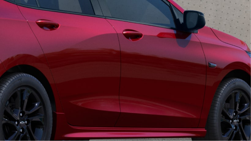 Detalle del perfil lateral del nuevo auto Chevrolet Onix Hatchback RS 2027 color rojo, mostrando sus líneas aerodinámicas fluidas y llantas de aleación en tono oscuro en Argentina.