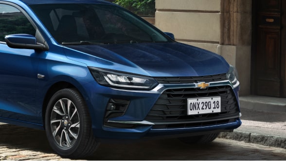 Vista en ángulo de tres cuartos frontal del nuevo auto Chevrolet Onix Hatchback 2027 color azul estacionado, acompañando la sección de financiación y beneficios del Plan Chevrolet en Argentina.