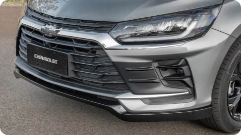 Vista frontal del nuevo Chevrolet Onix Hatchback 2027 luciendo el accesorio extensor del paragolpes delantero, sumando estilo y protección ideal para aventuras en Argentina.