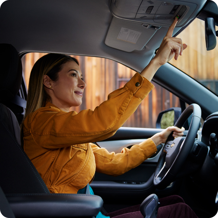 Conductora activando el servicio OnStar desde el panel del techo del nuevo Chevrolet Onix Hatchback 2027, una tecnología que asegura conectividad y protección continua en Argentina.