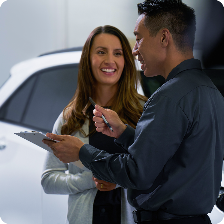 Propietaria utilizando la aplicación móvil myChevrolet en su smartphone junto a su vehículo, teniendo todo el control y servicios al alcance de sus manos en Argentina.