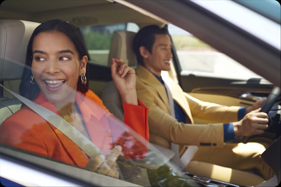 Pareja feliz disfrutando de un viaje en el interior de su vehículo, imagen que ilustra la facilidad de adquirir tu nuevo Chevrolet Onix Hatchback de forma transparente a través de Plan Chevrolet en Argentina.