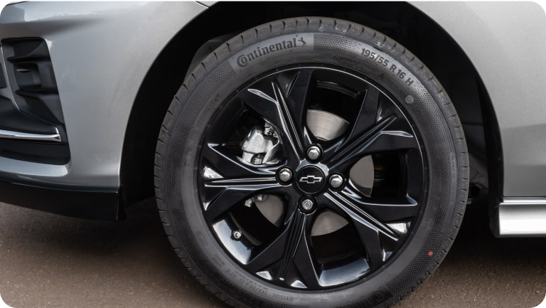 Vista en detalle de una de las llantas de aleación negra de 16 pulgadas del Chevrolet Onix Plus.