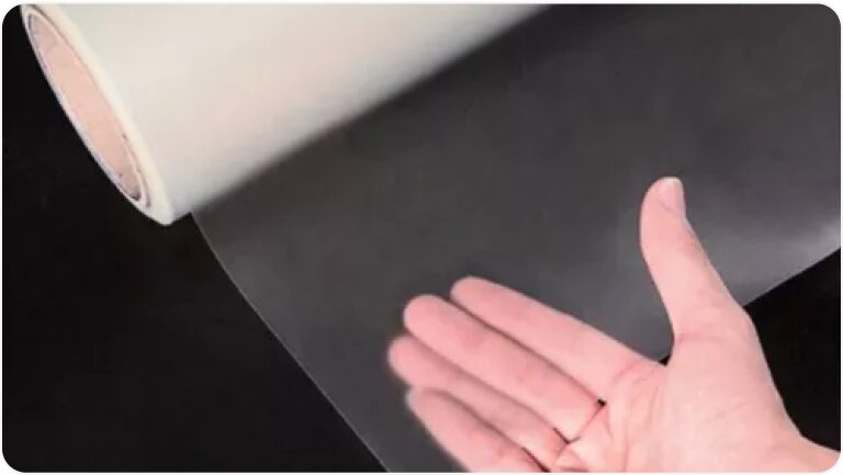 Vista en detalle del kit de película protectora de pintura junto a la mano de una persona.