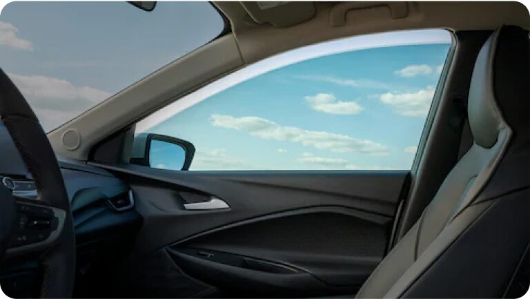 Vista interior de una de las ventanas delanteras de un Chevrolet Onix Plus, mostrando el rollo de película. 