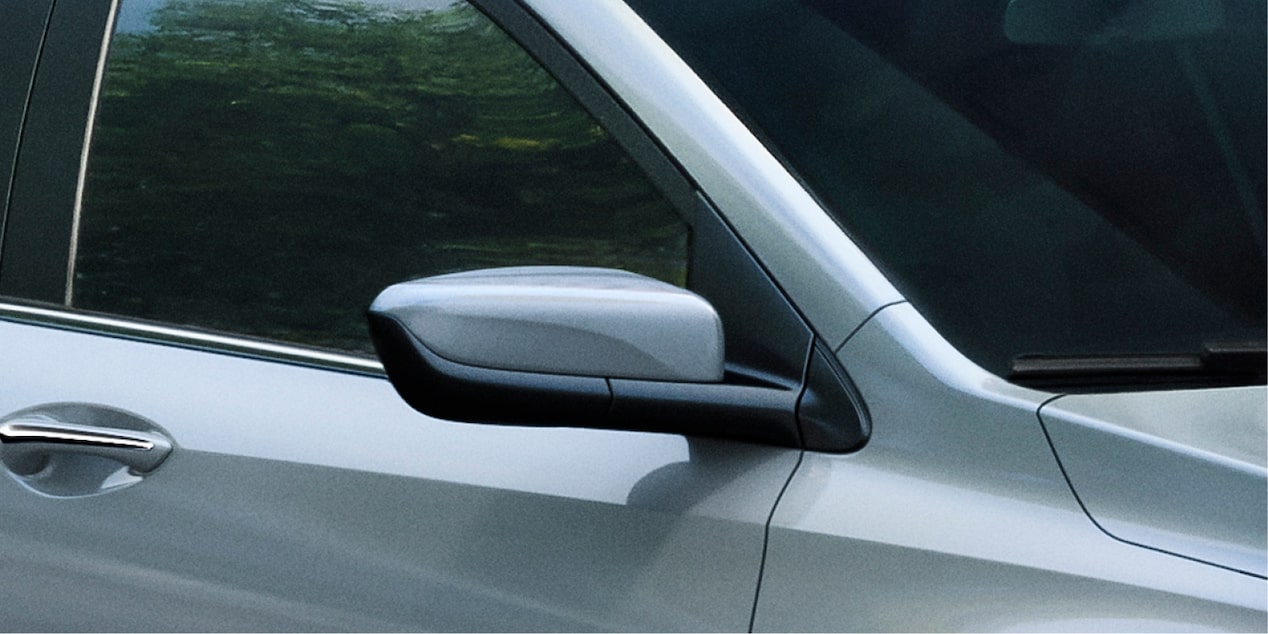 Detalle del espejo retrovisor lateral y línea de cintura del Chevrolet Onix Plus 2027 en Argentina