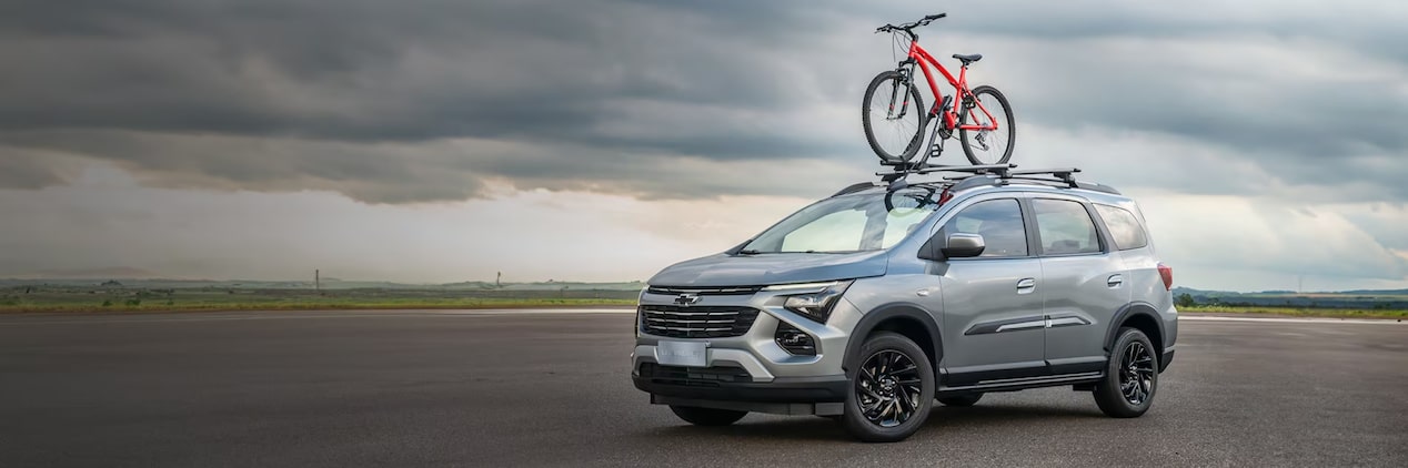 Vista de la nueva Chevrolet Spin color gris equipada con soporte y bicicleta en el techo, destacando la sección de accesorios de apariencia en Argentina.