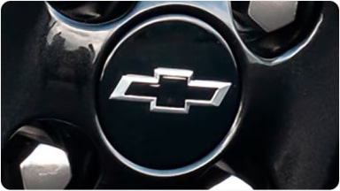 Detalle del centro de llanta de 16 pulgadas con acabado Carbon Flash y emblema Chevrolet negro, ideal para personalizar las ruedas de la nueva Chevrolet Spin en Argentina.