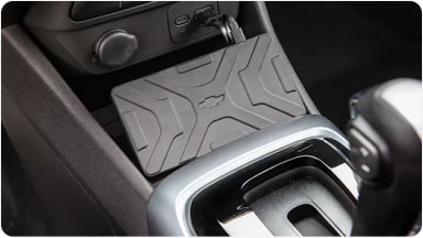 Práctico accesorio de cargador de celular por inducción integrado en la consola central, permitiendo la carga inalámbrica de smartphones en la nueva Chevrolet Spin en Argentina.