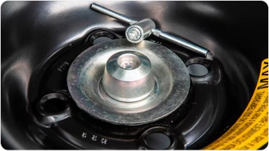 Accesorio de tuerca de seguridad junto a su llave especial, diseñado para proteger la rueda de auxilio contra robos en la nueva Chevrolet Spin en Argentina.