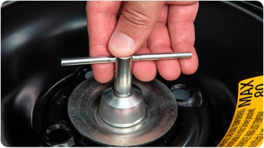 Detalle del uso de la llave especial suministrada con la tuerca de seguridad para la rueda de auxilio de la nueva Chevrolet Spin en Argentina.