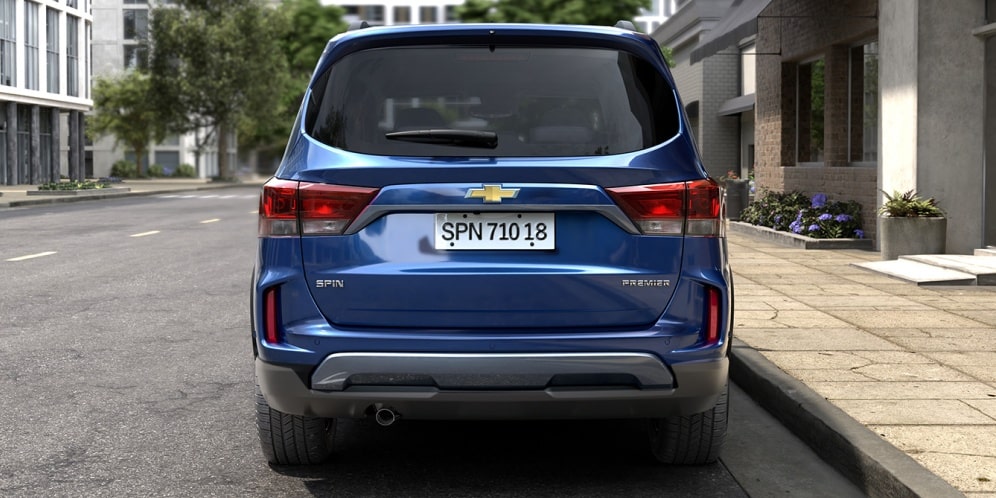 Vista trasera directa de la Chevrolet Spin 2027 azul mostrando las ópticas LED, paragolpes con protección inferior y logo Chevrolet dorado en Argentina.