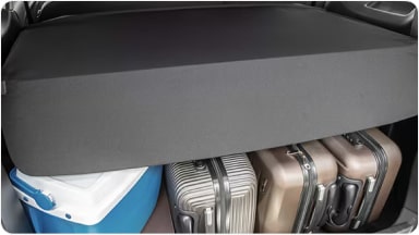 Accesorio cobertor para baúl extendido sobre maletas y conservadoras, protegiendo el equipaje en la nueva Chevrolet Spin en Argentina.