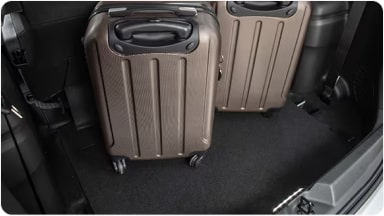 Baúl de la nueva Chevrolet Spin iluminado y con dos maletas cargadas, demostrando la comodidad al utilizar la luz auxiliar LED en Argentina.