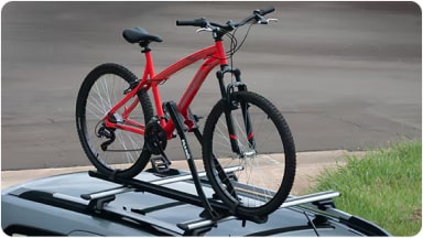 Accesorio portabicicletas de acero montado sobre las barras de techo, ofreciendo un transporte seguro y estable para bicicletas en la nueva Chevrolet Spin en Argentina.