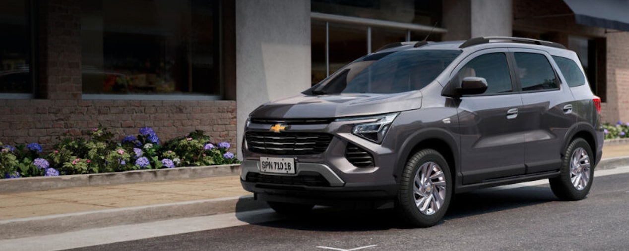 Vista frontal y lateral de la nueva Chevrolet Spin color gris en un entorno urbano, introduciendo la sección de paquetes de accesorios en Argentina.