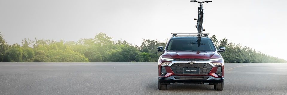 Vista frontal de la Chevrolet Tracker con una bicicleta montada en el soporte para el techo con vegetación de fondo.