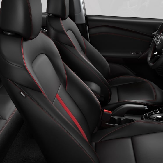 Vista lateral de los asientos delanteros de Chevrolet Tracker, con tapizados oscuros, detalles y costuras rojas, apoyacabezas y diseño envolvente.