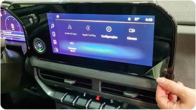 Accesorio de película protectora contra rayones siendo instalada en la pantalla central del sistema MyLink de la SUV Chevrolet Trailblazer en Argentina.