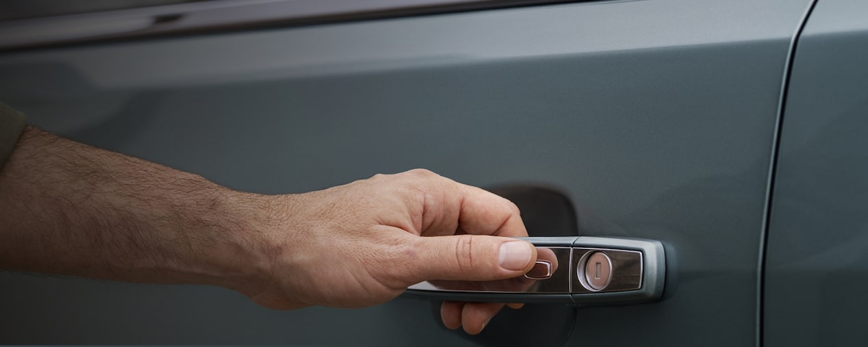Vista en detalle de una mano abriendo la puerta de la SUV Chevrolet Trailblazer, introduciendo la sección de accesorios de confort en Argentina.