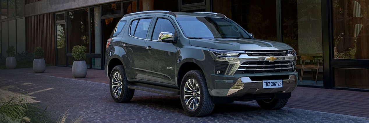 SUV Chevrolet Trailblazer color verde oscuro estacionada en un entorno residencial moderno, destacando sus accesorios de apariencia exterior en Argentina