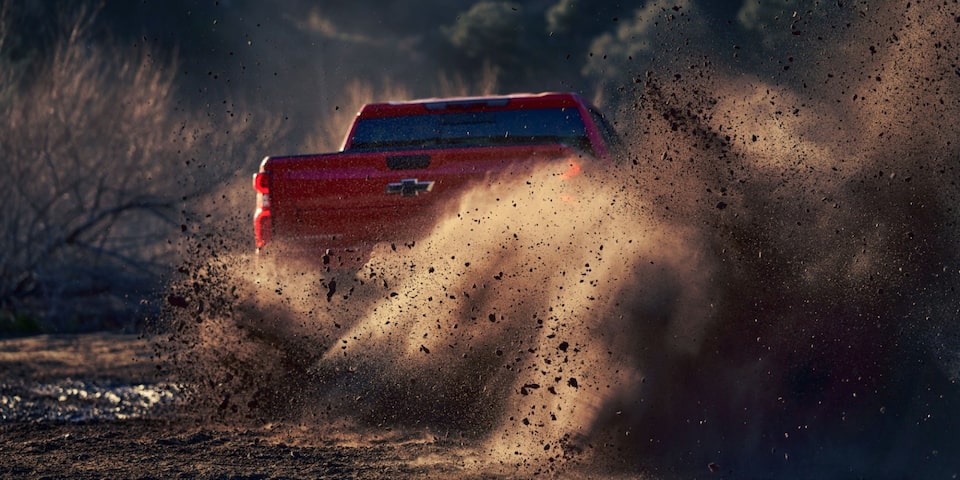 Vista trasera de la Chevrolet Silverado derrapando en camino de tierra.