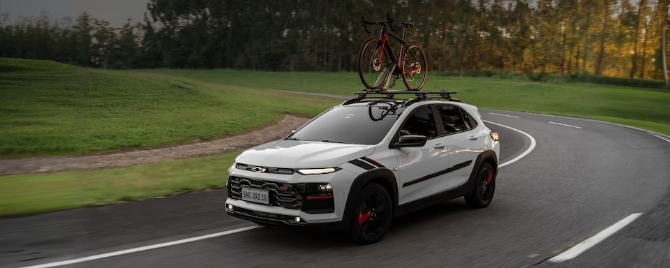 Chevrolet Sonic circulando por una ruta equipado con un porta bicicleta.
