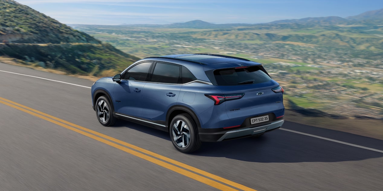 Vista trasera de la Chevrolet Captiva PHEV ascendiendo sobre una ruta elevada, con montañas y naturaleza de fondo. 