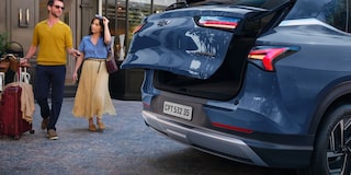 Imagen de un hombre y una mujer saliendo de un hotel a punto de cargar sus valijas en el baúl de la Chevrolet Captiva PHEV.