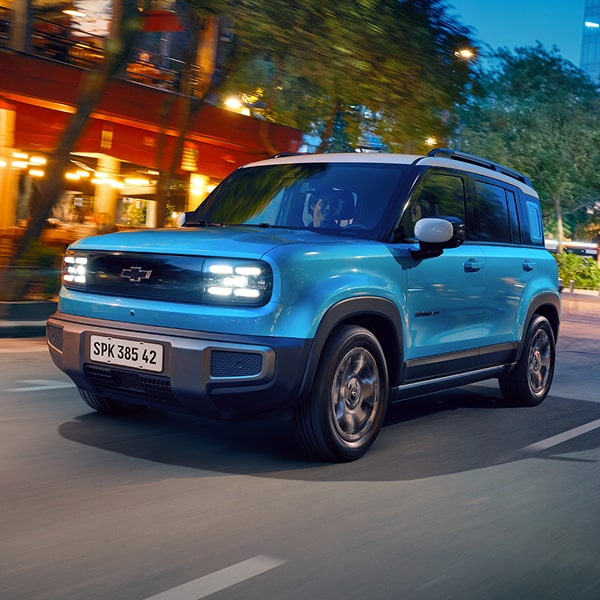 Vista frontal de la Chevrolet Spark EUV circulando por una zona urbana de noche.