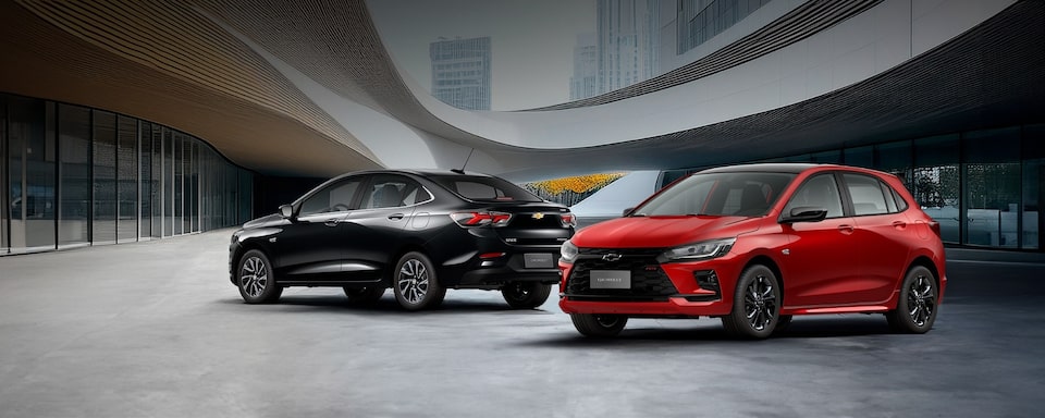 Chevrolet Onix 2026 color Rojo Jinx y Onix Plus 2026 color Negro Black Meet Kettle estacionados en área urbana