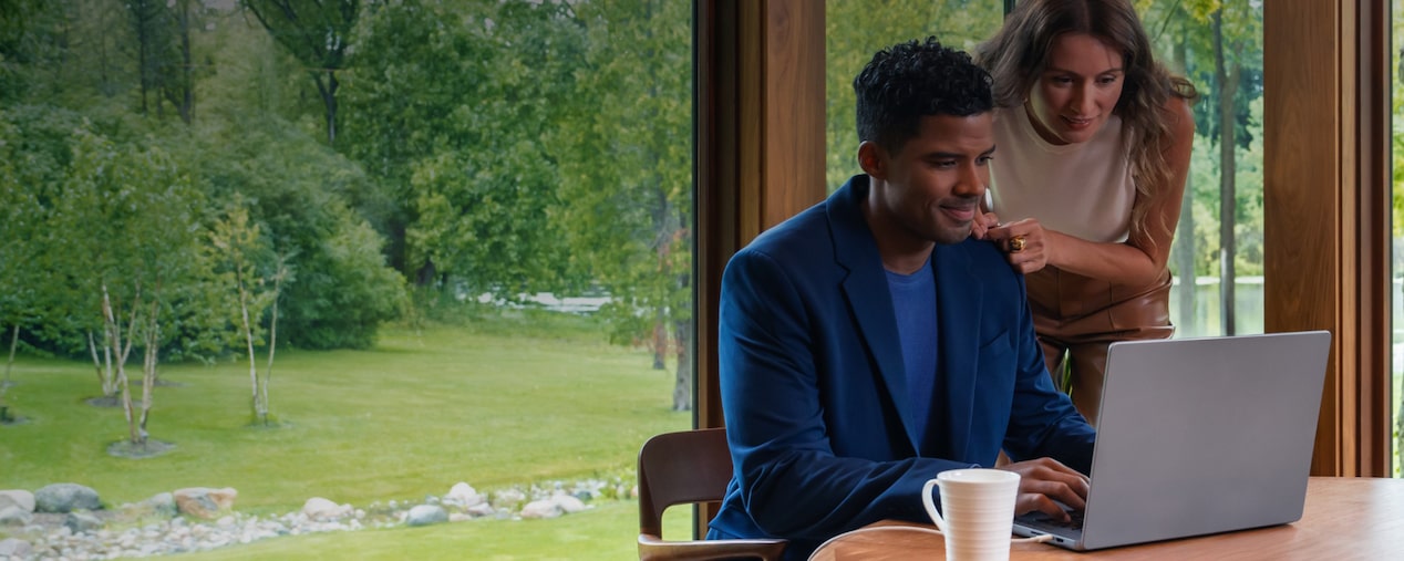 Dos personas en un entorno profesional junto a una mesa con portátil y taza de café, revisando información bajo el encabezado 'Condiciones Generales', imagen que representa la colaboración y revisión de términos de la suscripción digital Chevrolet.
