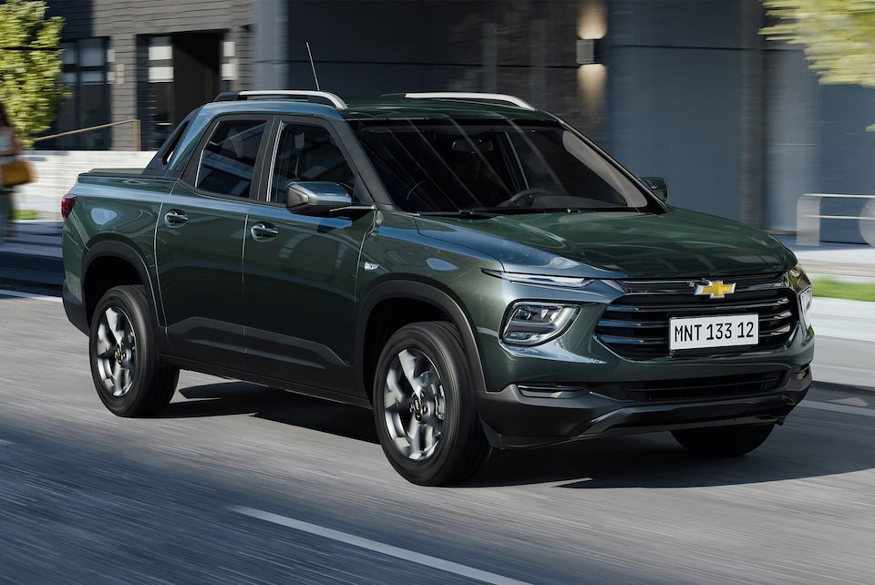 Chevrolet Montana 2025 en color verde circulando por una avenida urbana con diseño moderno y robusto