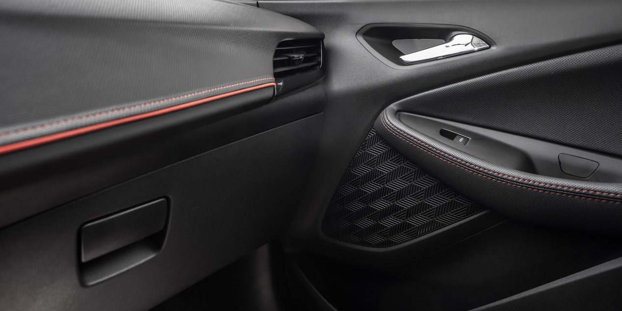 Vista en detalle del panel interior de la puerta de una Chevrolet Montana 2026, con terminaciones en color Jet Black con detalles en rojo y negro High Gloss.