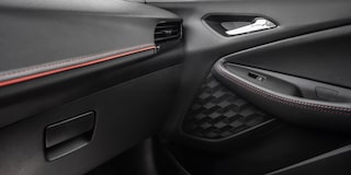 Vista en detalle del panel interior de la puerta de una Chevrolet Montana 2026, con terminaciones en color Jet Black con detalles en rojo y negro High Gloss.