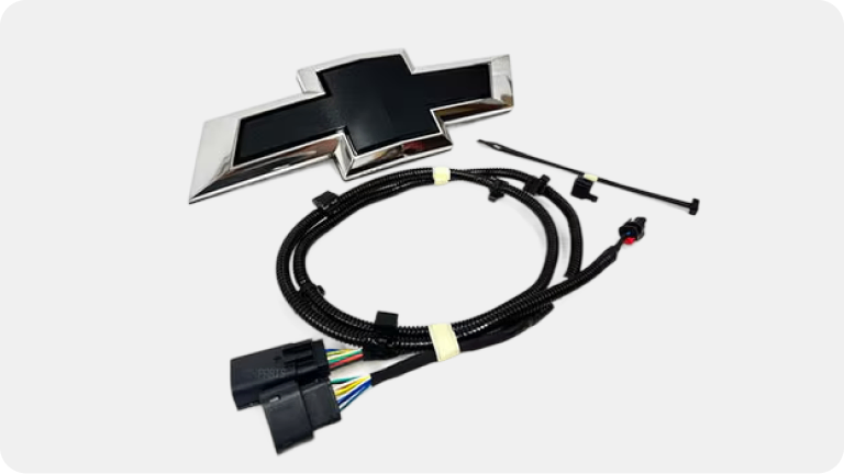 Imagen del emblema de Chevrolet y sus cables para la instalación.