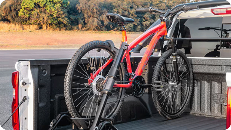 Imagen del portabicicletas para caja, en la caja de una Chevrolet Silverado, con una bicileta encima.