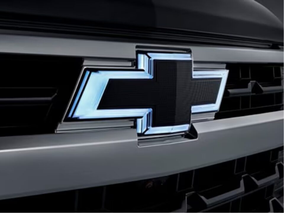 Imagen en primer plano de la parrilla delantera de la nueva pick-up Chevrolet Silverado destacando el logo de Chevrolet iluminado con un contorno de neón.