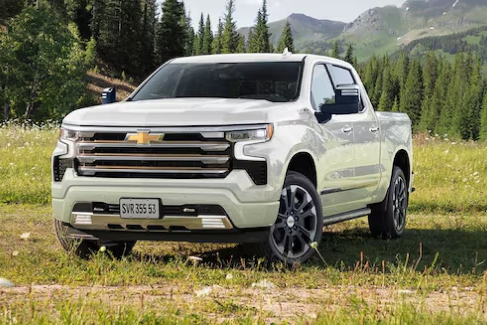 Imagen del frente de la nueva Chevrolet Silverado estacionada sobre césped y con montañas de fondo. 