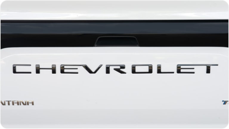 Emblema de Chevrolet en el portón trasero en letras negras en relieve de la Montana.