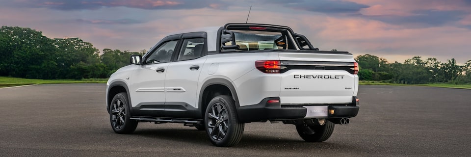 Vista trasera de la Chevrolet Montana con vegetación de fondo.