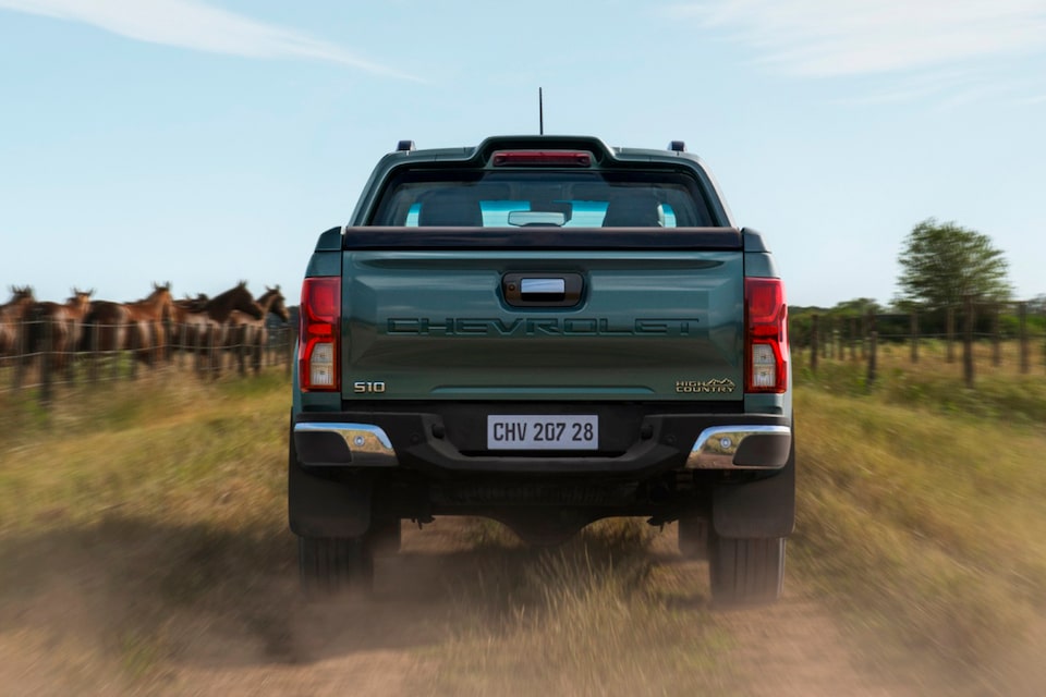 Vista trasera de la Chevrolet S10 High Country conduciendo en camino rural.