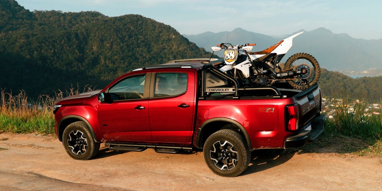 Chevrolet S10 Z71 2027 color rojo estacionada en la montaña cargando una moto de motocross en la caja en Argentina