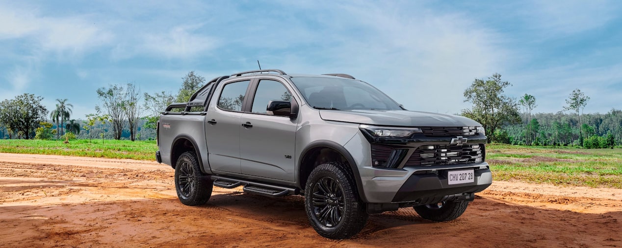 Chevrolet S10 Trail Boss circulando por un camino de tierra con vegetación de fondo.